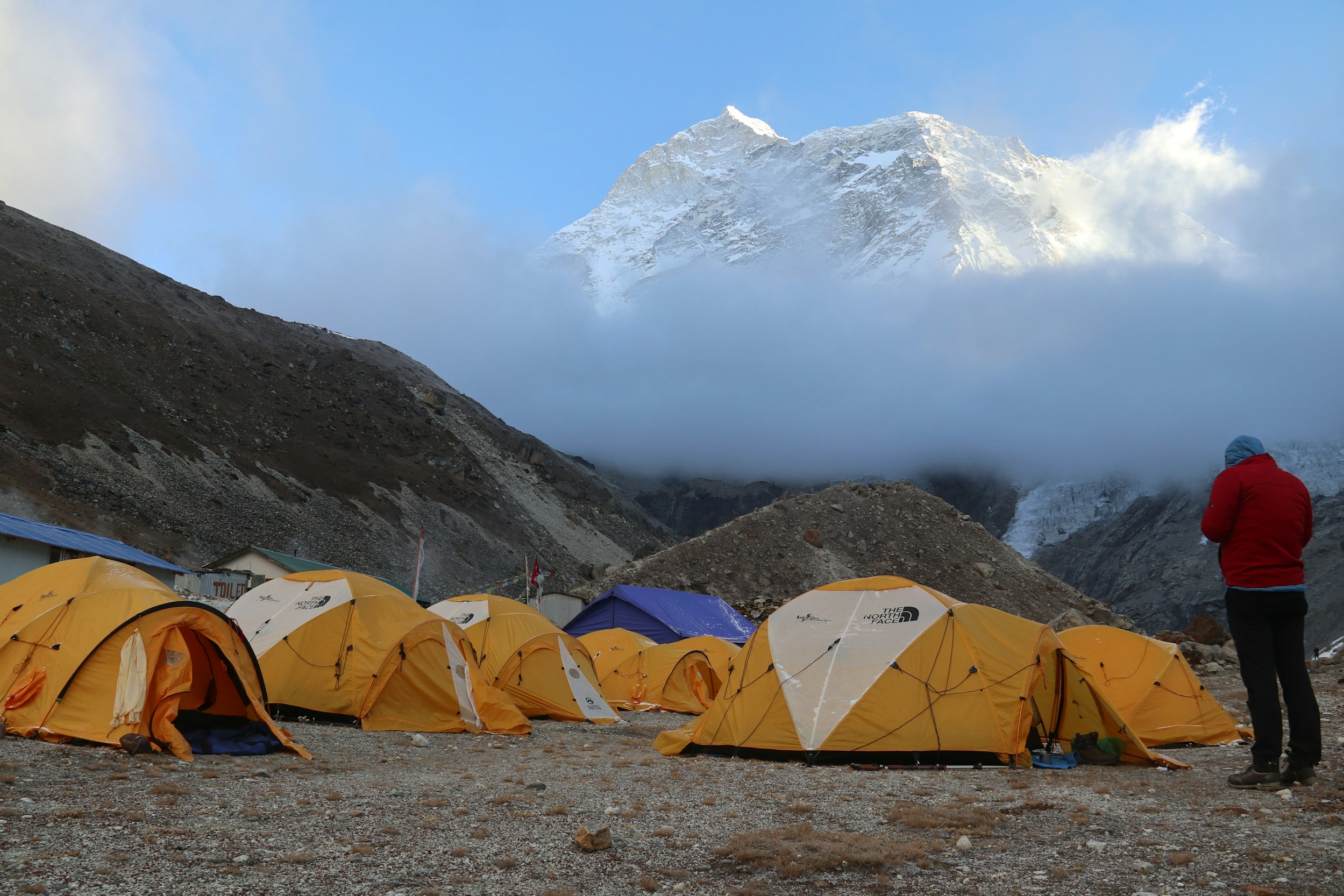 Tents at Everest Base Camp below a cloud-wrapped summit